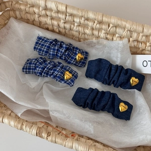 Detail of blue scrunchie hair clips with golden heart buckles in a gift basket