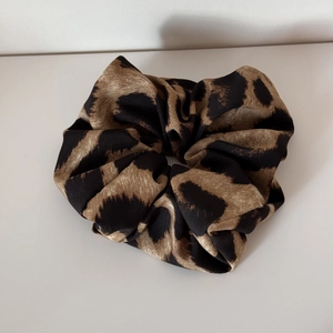 Close-up of vintage leopard print scrunchie showing fabric texture and elastic design
