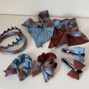 Vue à plat d'un ensemble d'accessoires de cheveux à carreaux avec serre-tête et nœuds