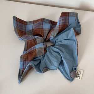Vue détaillée du chouchou en tissu à carreaux et bleu avec étiquettes faites à la main