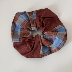 Détail d'un chouchou à carreaux rouge et bleu avec tissu élastique et design texturé
