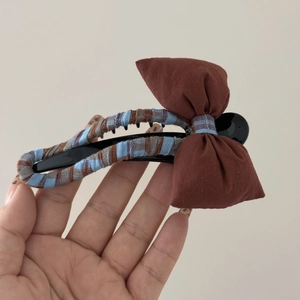 Vue détaillée d'une pince à cheveux à carreaux avec un grand nœud décoratif marron