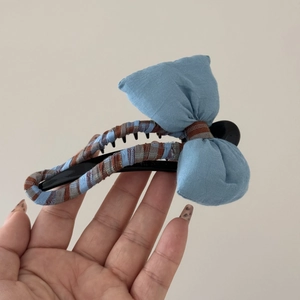 Détail de la pince à cheveux banane à carreaux bleus avec un nœud en coton doux