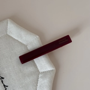 Détail de la pince à cheveux en acrylique bordeaux avec gravure France Handmade dorée