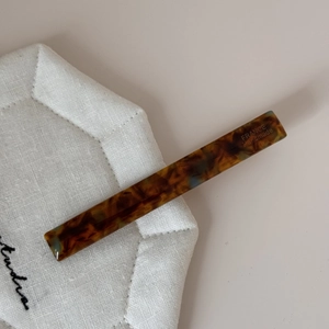 Détail de la pince à cheveux en écaille ambrée avec gravure France Handmade artisanale