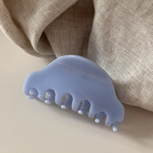 Détail macro d'une pince à cheveux en acétate bleu clair avec finition résine
