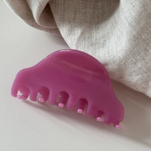 Détail de la pince à cheveux demi-cercle en acétate bordeaux avec une finition brillante