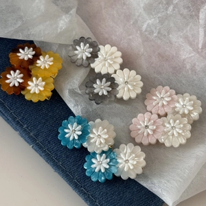 Close-up of daisy floral hair clips with embedded rhinestones in assorted colors