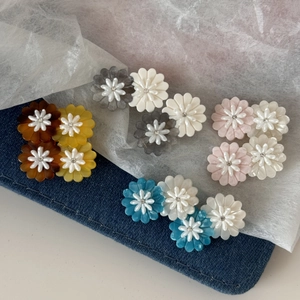 Detailed close-up of acetate daisy flower hair clips with marble texture and pearl accents