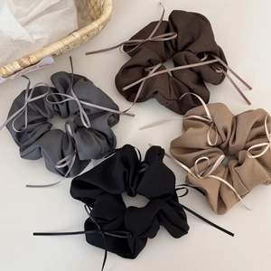 Détail de quatre chouchous avec nœuds en ruban en café noir, gris, beige et noir
