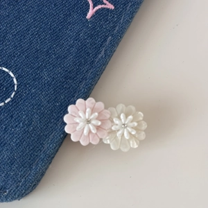 Detail of small pink and white daisy hair clips with resin petals and center rhinestones