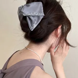 Elegant grey organza hair claw with sparkling silver rhinestones on a female model