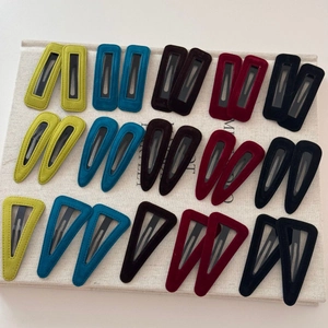 Macro view of velvet-covered geometric BB hair clips in five vintage colors and three shapes