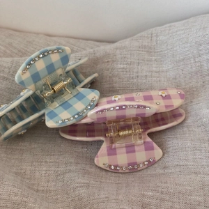Dettaglio di fermagli per capelli in acetato a scacchi con strass e decorazioni floreali