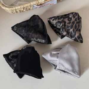 Detailed view of four satin hair clips featuring leopard prints and sparkling rhinestones