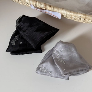 Detail of silk hair accessories featuring hand-stitched sequin floral embroidery patterns
