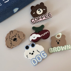 Gros plan de barrettes mignonnes en résine avec chiots, oursons et motifs de cerises