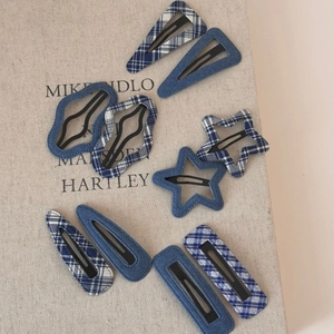 Detailed view of blue denim and plaid fabric hair clips in assorted geometric shapes