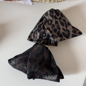 Close-up of leopard print hair claw with sparkling crystal beads on mesh fabric