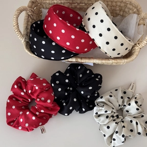 Polka dot satin scrunchies and headbands in black red and white on a woven basket
