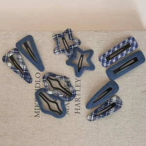 Detailed close-up of denim and plaid fabric hair clips in star and geometric shapes
