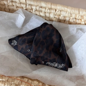 Detailed macro view of leopard print sheer fabric with silver crystal floral embellishments