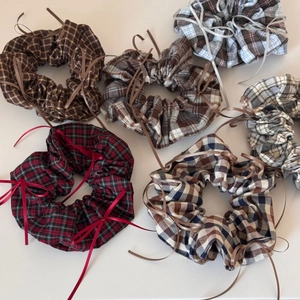 Close-up of ballet style plaid scrunchies with delicate ribbon bows in various colors