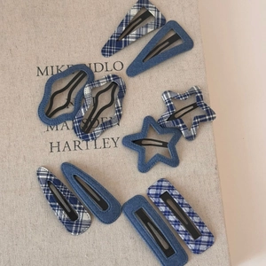 Detailed macro view of denim and blue checkered fabric BB hair clips set on a book