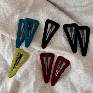 Detailed view of assorted triangular velvet hair clips in deep vintage autumn colors