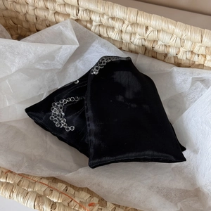 Detail of sheer black mesh socks featuring decorative silver rhinestone ring patterns