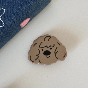 Détail d'une pince à cheveux en forme de petit chien brun avec visage de dessin animé