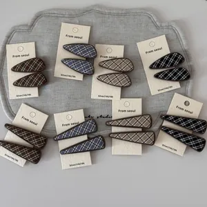 Detail view of British plaid fabric hair clips in various geometric patterns on card