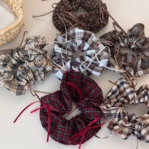 Detailed close-up of multiple vintage plaid scrunchies with ribbons on a white background