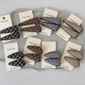 Close-up of British plaid fabric hair clips in geometric triangle and teardrop shapes