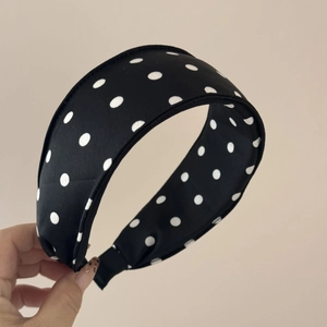 Close-up of fluffy black and white polka dot satin scrunchie with soft premium texture