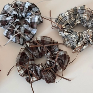 Detailed view of ballet style plaid hair scrunchies with elegant ribbon bow accents
