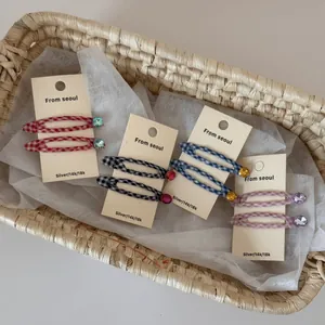 Detailed view of colorful plaid fabric BB hair clips with rhinestone accents in a basket