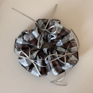 Detail shot of vintage plaid scrunchie with silver ribbons and elegant bow accents