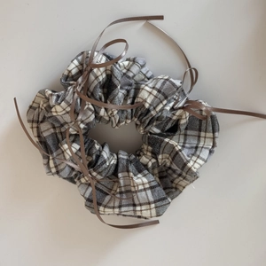 Detail of plaid scrunchie with brown ribbons and ballet-inspired checkered fabric