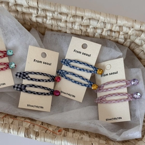 Checkered fabric hair clips with rhinestones in black, blue, and pink patterns