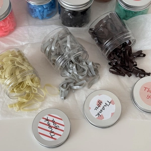 Gros plan d'élastiques à cheveux colorés dans des bocaux transparents à couvercles