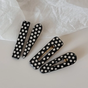 Elegant 4-piece set of black and white polka dot hair clips in various teardrop shapes