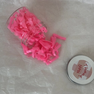 Élastiques à cheveux roses larges rangés dans un pot transparent avec couvercle décoré