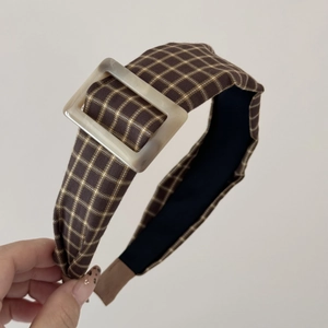 Detail view of American vintage brown plaid headband with a square marble buckle decoration