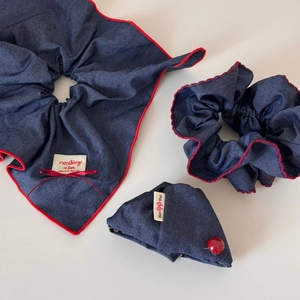 Three-piece navy denim scrunchie set with red lace edges and decorative button clip