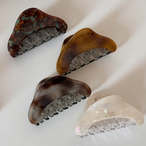 Set of four large acetate hair claws in tortoise shell, amber, marble, and pearl white colors