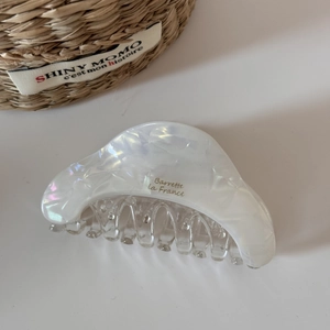 Detail of pearl white acetate hair claw clip with golden Barrette La France text logo