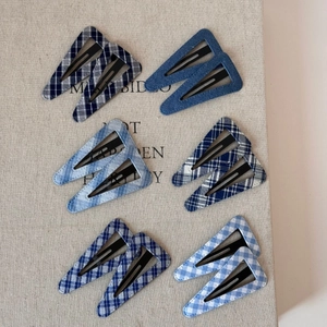 Macro shot of assorted blue denim and plaid fabric covered triangular BB hair clips