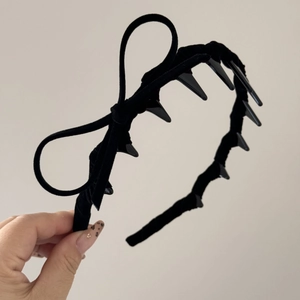 Detail view of velvet headband with side bow and built-in plastic styling teeth