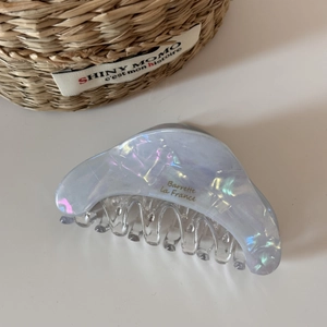 Macro detail of large iridescent acetate hair claw clip with golden Barrette La France text
